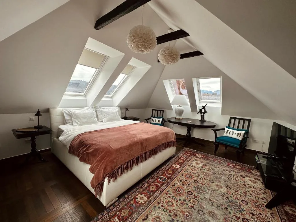 Penthouse bedroom beneath exposed beams and roof windows
