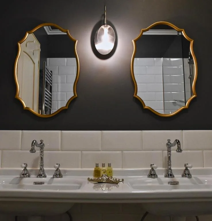 Twin basins and gilt mirrors in the Suite with Lake View bathroom